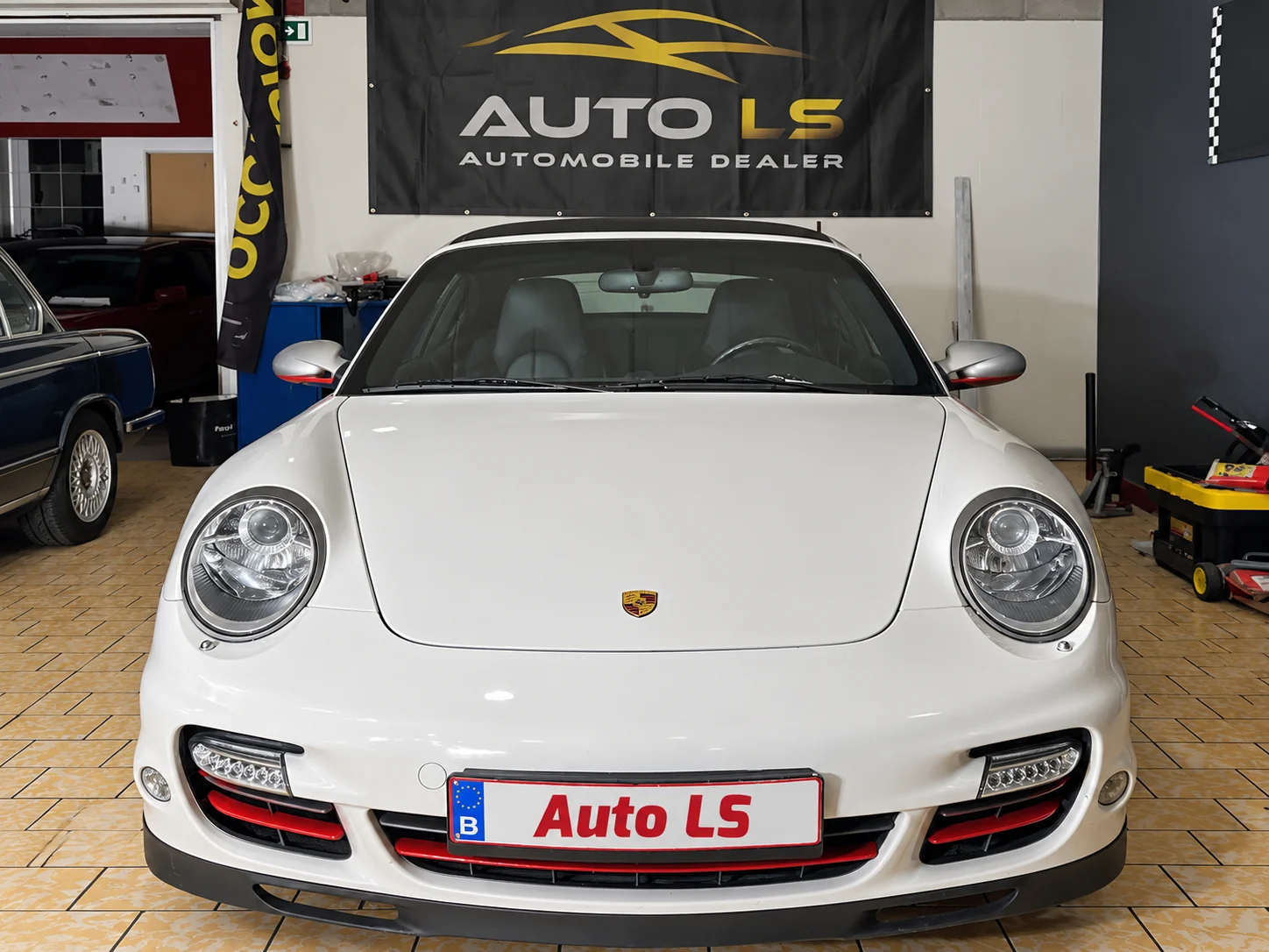 Porsche blanche exposée dans le showroom Auto LS